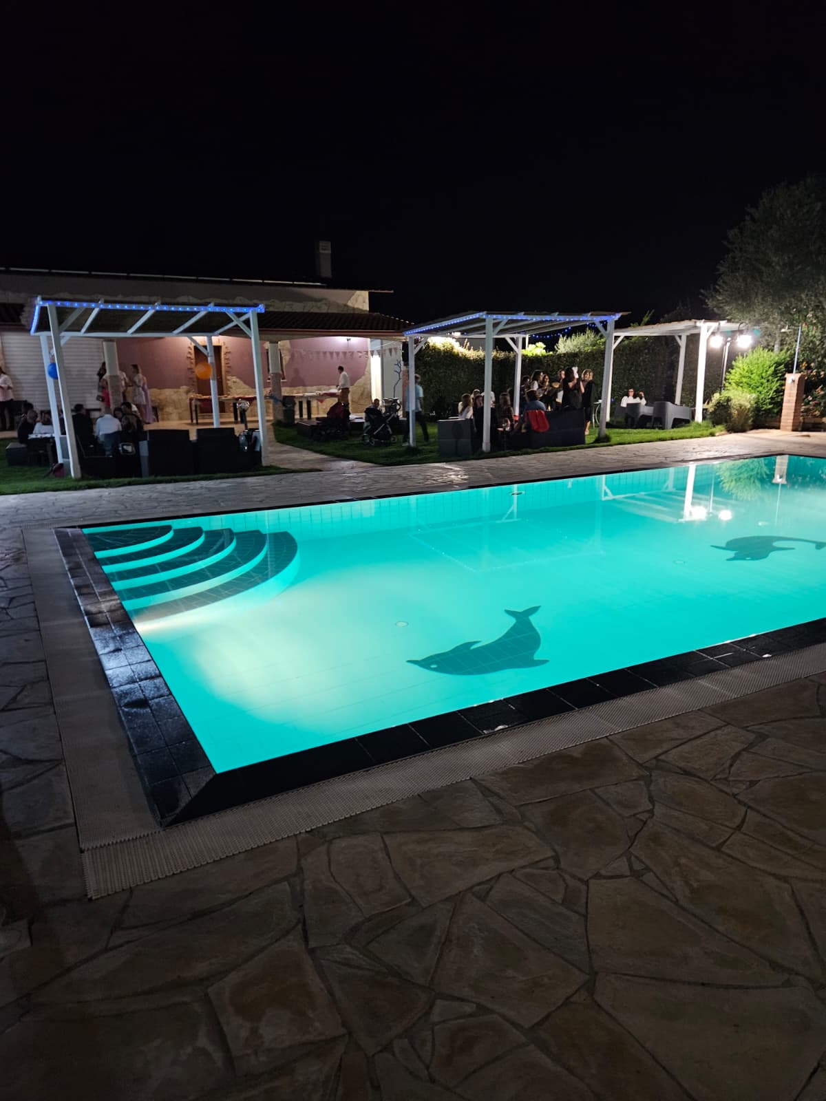Piscina illuminata di sera con ospiti - eventi privati L'Antica Fonte