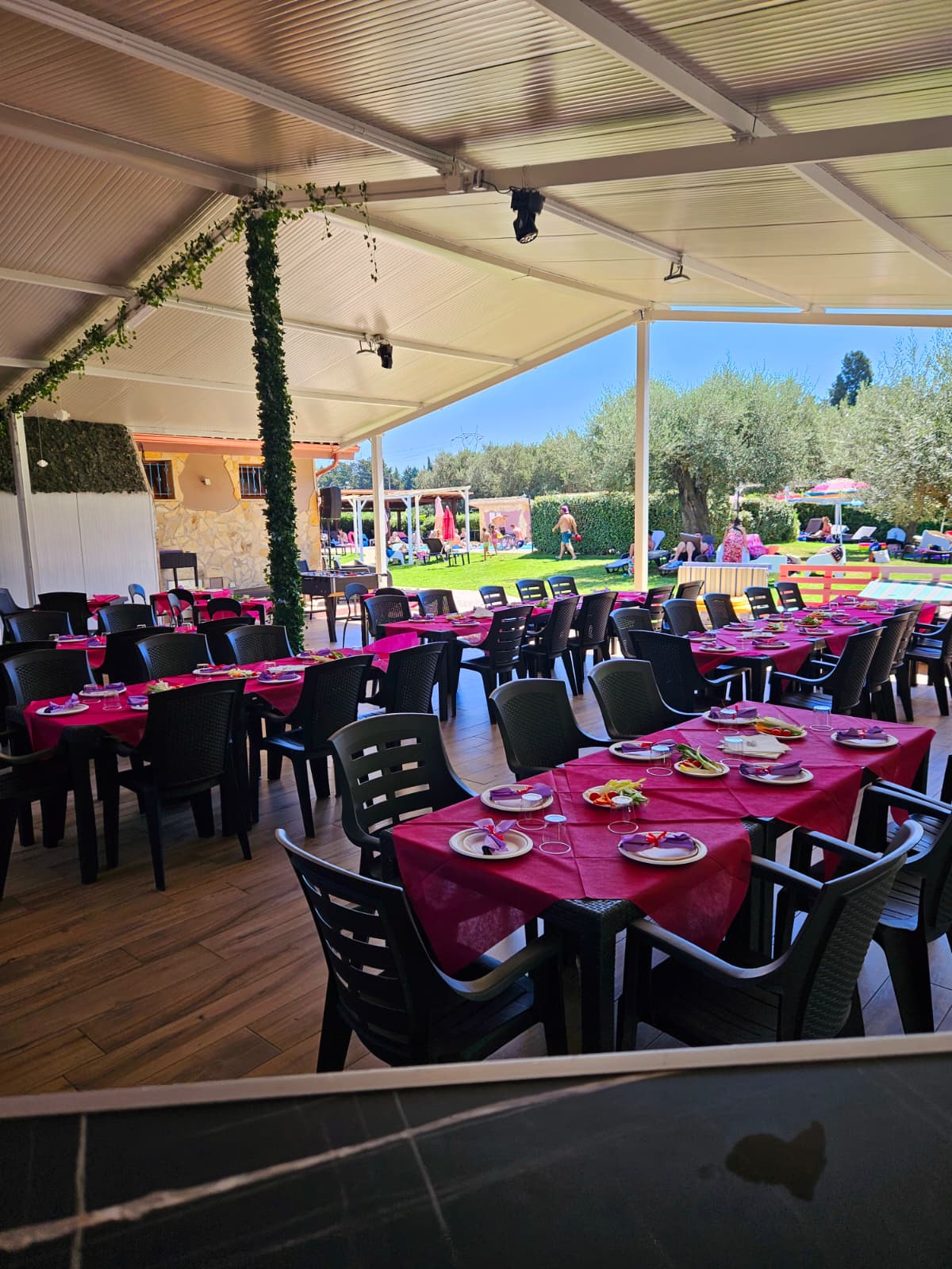 Sala coperta allestita per pranzo con tovaglie fucsia
