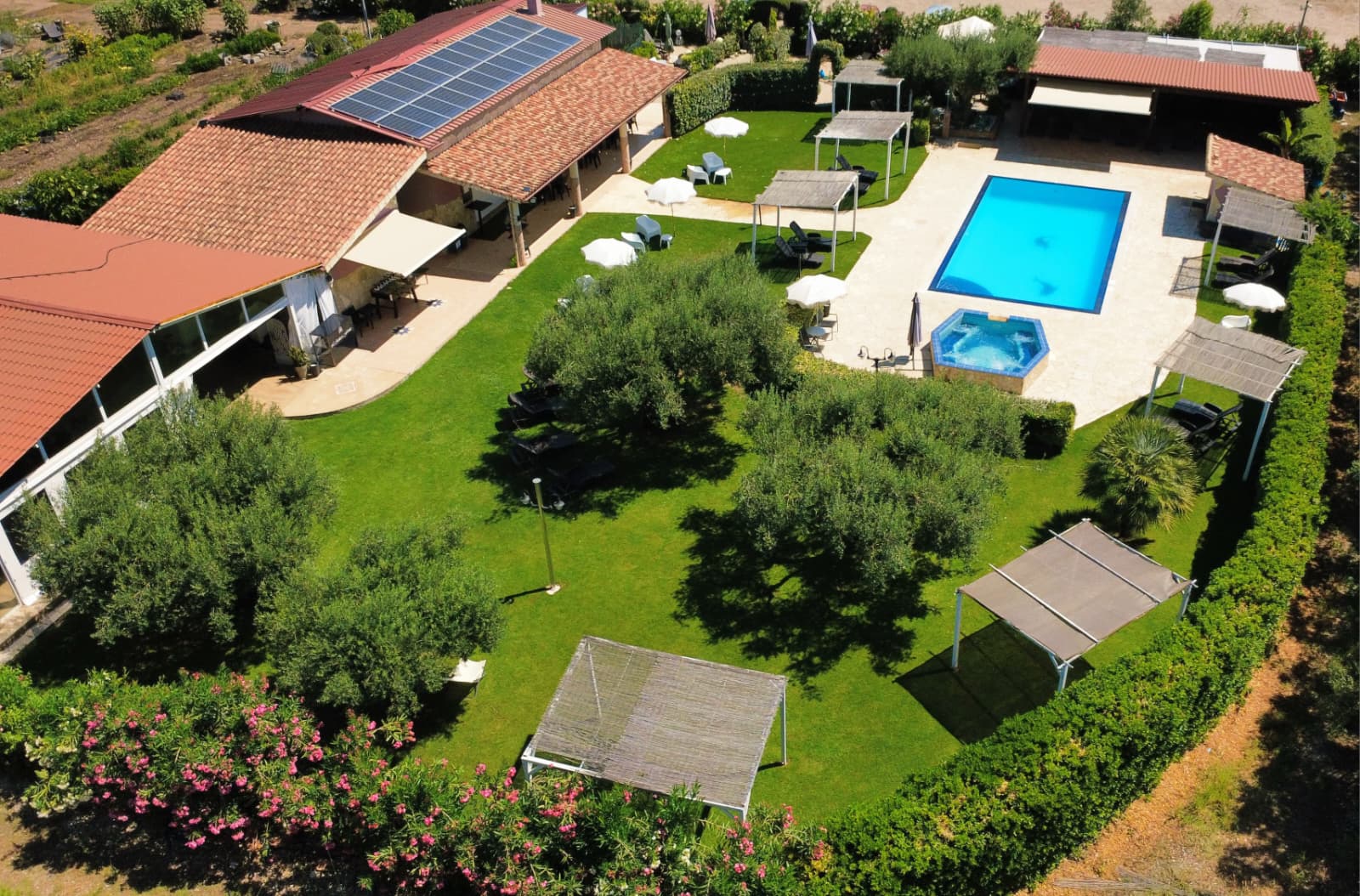 Vista aerea della struttura L'Antica Fonte con piscina, idromassaggio e giardino di ulivi